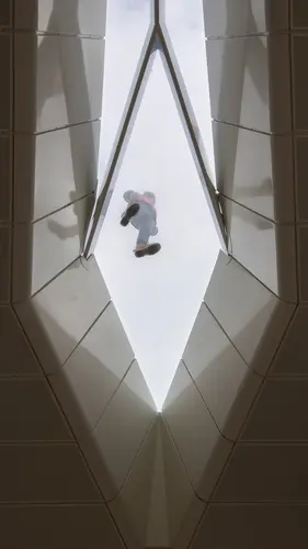 Looking up at Central Station vaulted roof. A construction worker is seen standing on top of the glass roofing