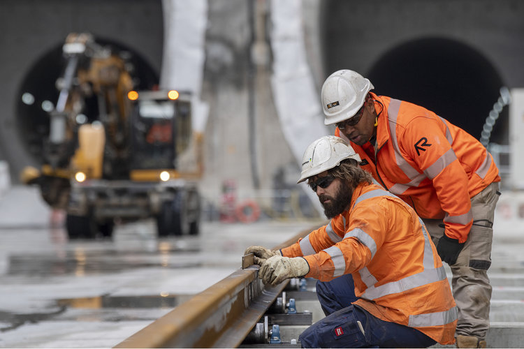 Two construction workers inspecting the rail track at Waterloo Station