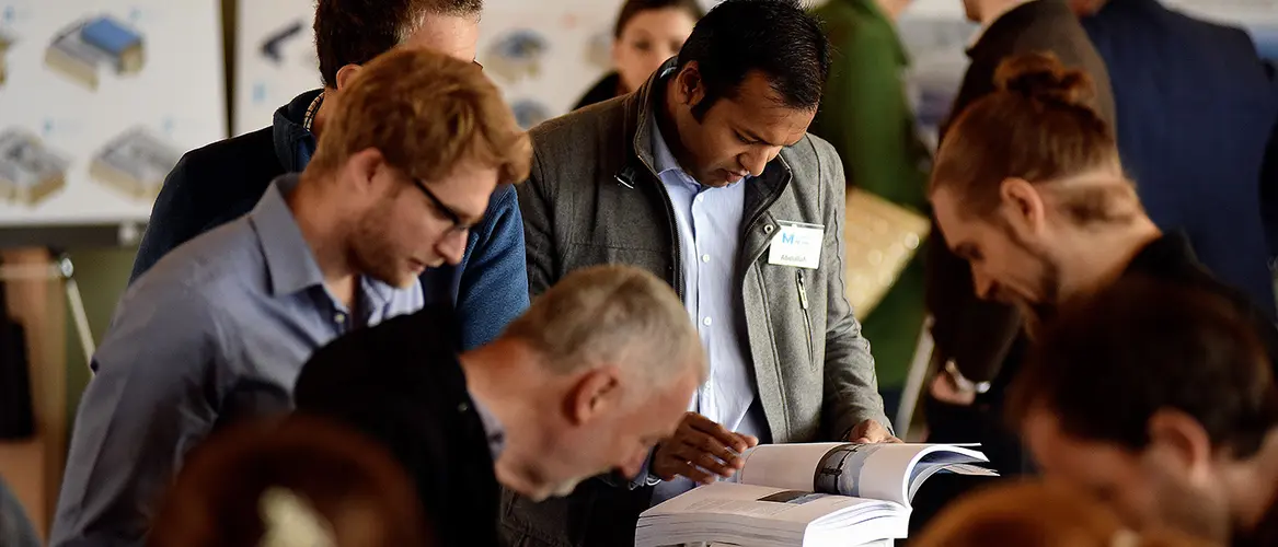 A close up shot showing community members grouped together as they are reading information booklets at a Sydney Metro Community Information Session. 