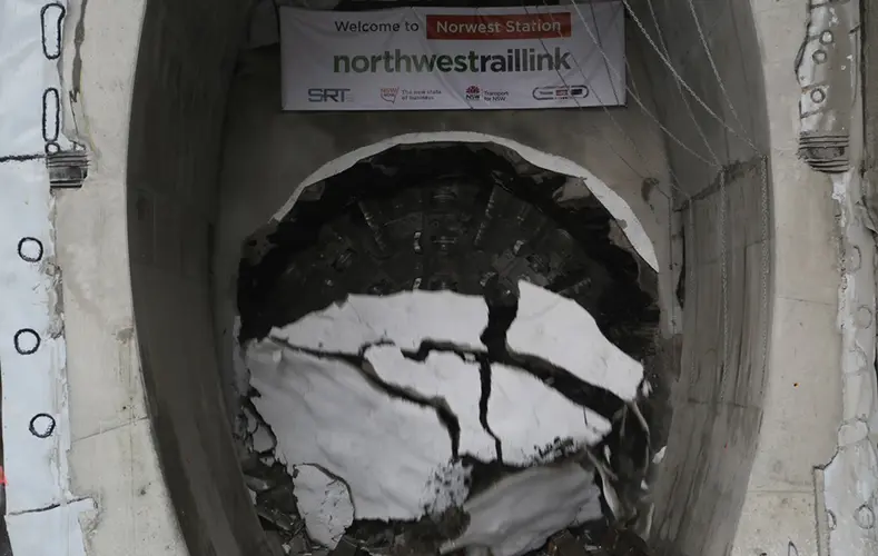 An on the ground view showing Tunnel Boring Machine (TBM) 2 Florence breaking through the stone that is shattering to the ground at Sydney Metro's Hills Showground Station as part of the North West Rail Link project.