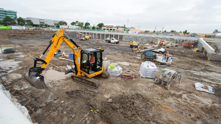 A man works inside a digger on the Bella Vista Station construction site.