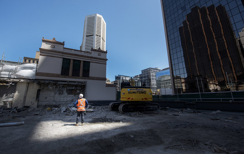 An on the ground view showing a construction worker inspecting the demolition site at Sydney Metro's Martin Place Station.