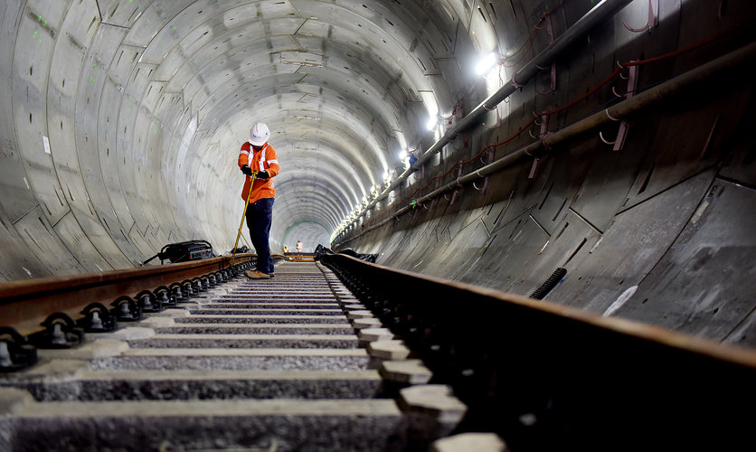 An on the ground view of a construction worker completing track work inside the first Sydney Metro tunnel track. 