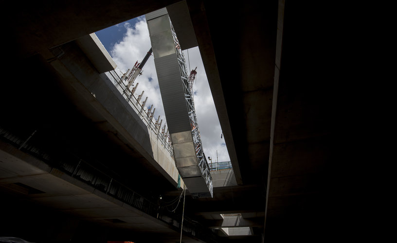 An on the ground view looking up at the escalators being craned into place at Sydney Metro's Norwest Station.