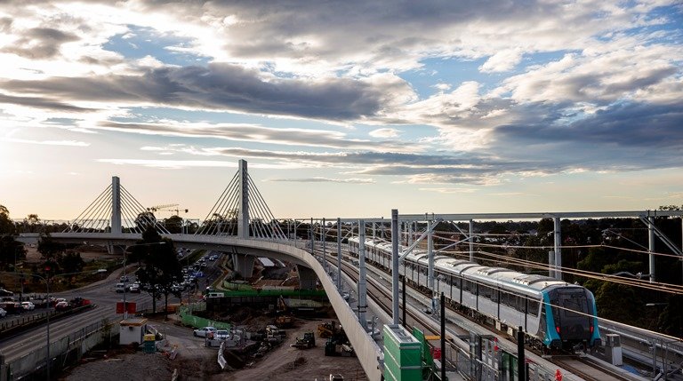 An arial view of a Sydney Metro train being tested on the completed tracks at Windsor Road Bridge. 