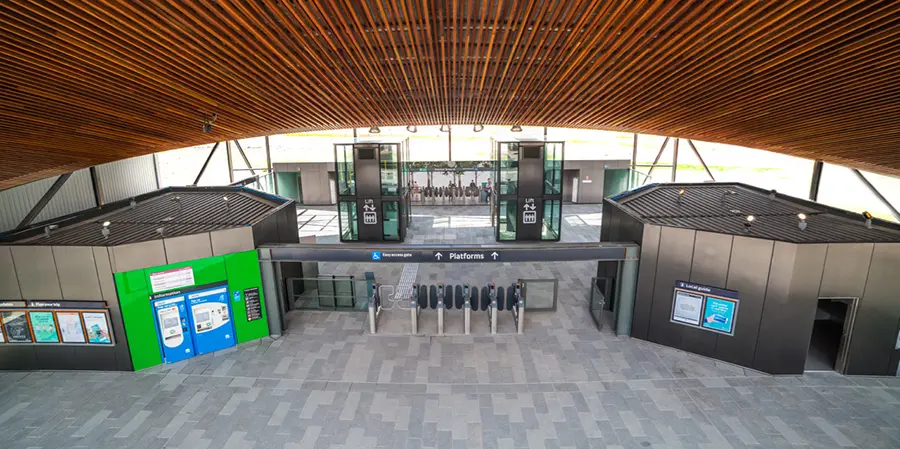 An Artist's impression of the station concourse entrance for Sydney Metro's Northwest Station prototype, showing the entrance barriers, signage to the platforms and lifts to go down onto the platform.