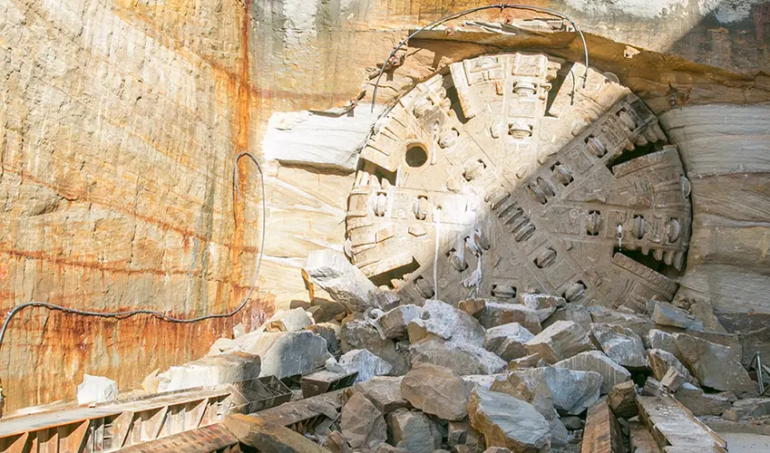 An on the ground view showing Tunnel Boring Machine (TBM) 1 Elizabeth breaking through the stone at Sydney Metro's Hills Showground Station.
