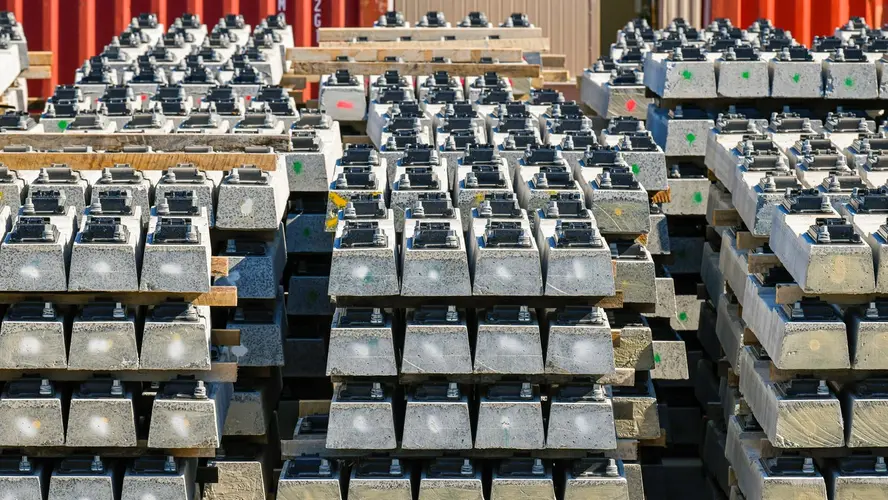 Close up view of stacks of pre-cast concreate are lined up in front of several shipping containers at Sydney Metro Trains Facility South Yard.