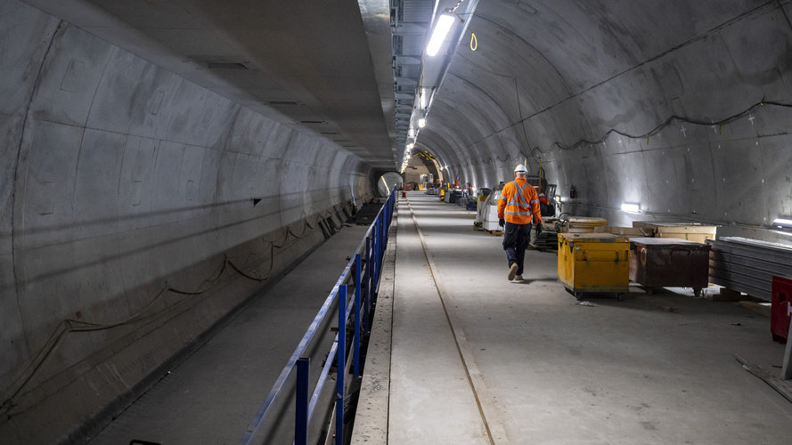 A construction worker walks down the underground tunnel inside Pitt Street Station Cavern.