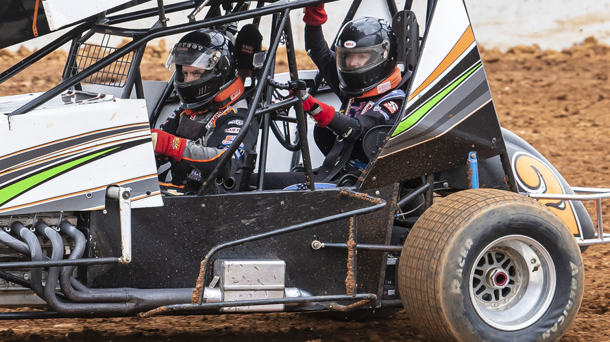 Two people are inside a race car driving in in the dirt track at the new Eastern Creek Speedway.