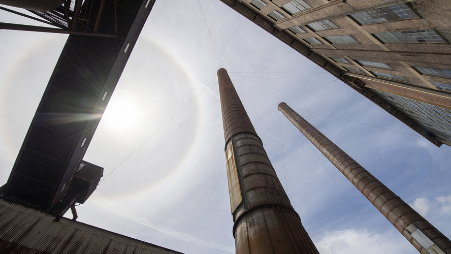 A view from the ground looking up at the sky at large smoke stacks at White Bay Power Station.