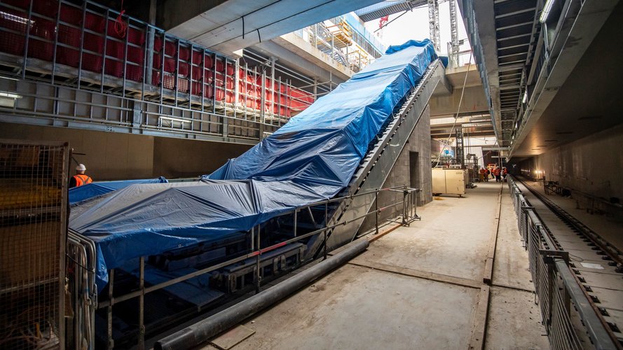 Side angle view of the new escalators covered in blue tarp that are ready for installation on B3 level (concourse) down to the platform level at Waterloo station