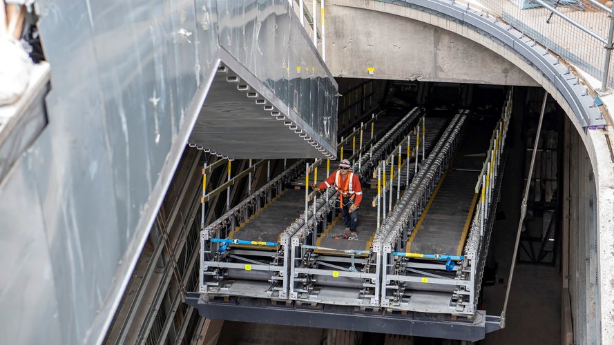 A construction worker attaches ones section of escalators to another at Central Station.