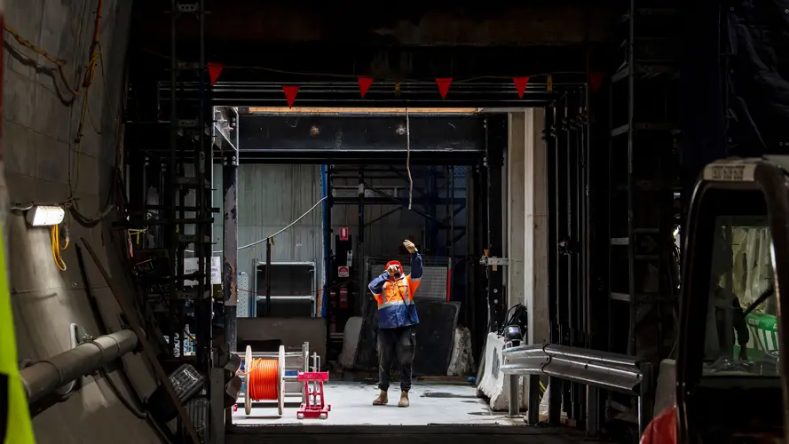 On the ground view of construction worker looking up at Sydney Metro's Victoria Cross Station North Cavern.
