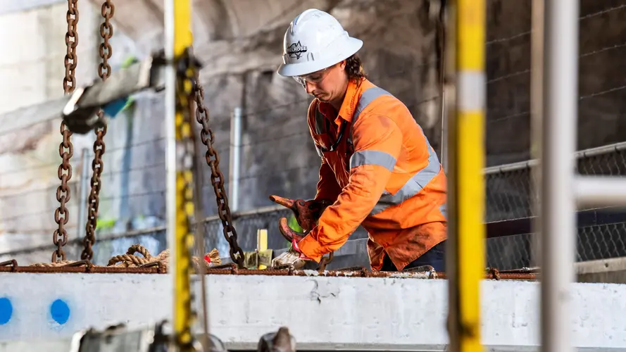 Construction worker in hard hat installing platforms at Barangaroo Station.