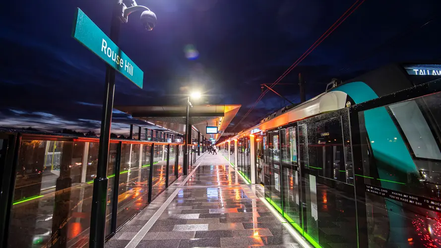 Sydney Metro train at the platform at Sydney Metro's Rouse Hill Station at night.