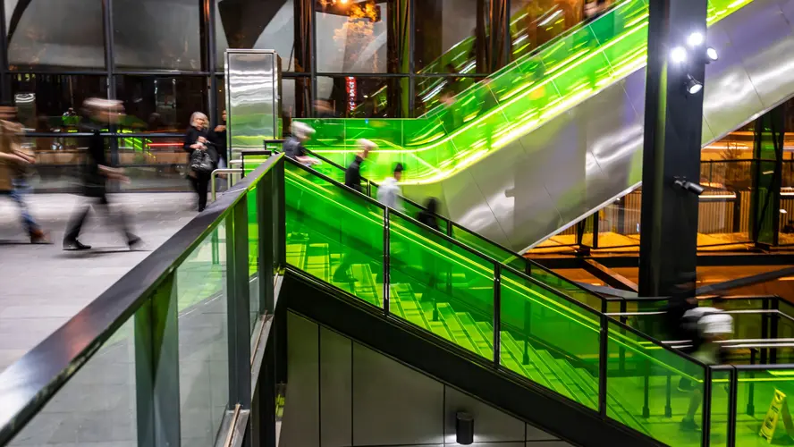 Ground level view of passengers using the stairs and escalators at Sydney Metro's Rouse Hill Station.