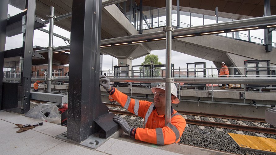 Construction workers installing platform screen doors at Sydney Metro's Sydenham Station.