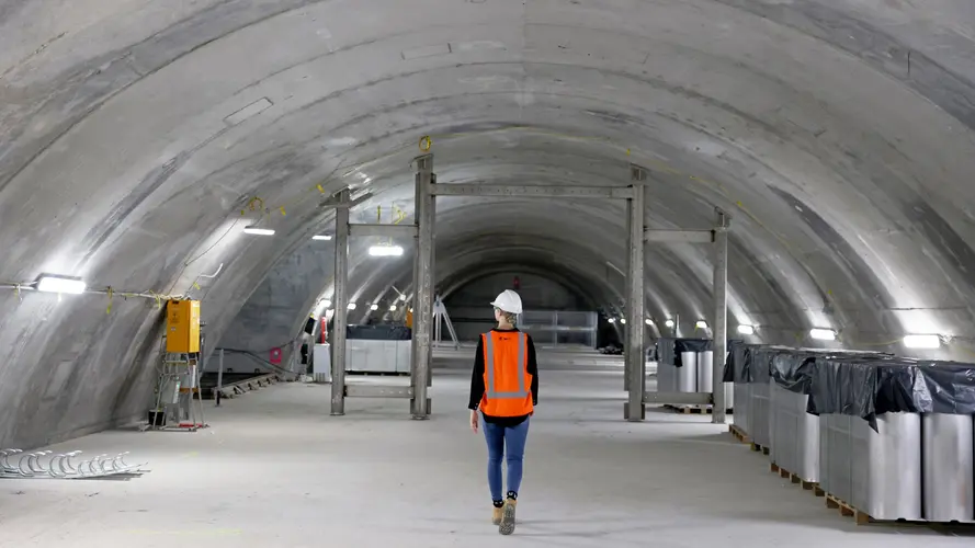 Construction worker walking through the underground caverns at Sydney Metro's Martin Place Station.