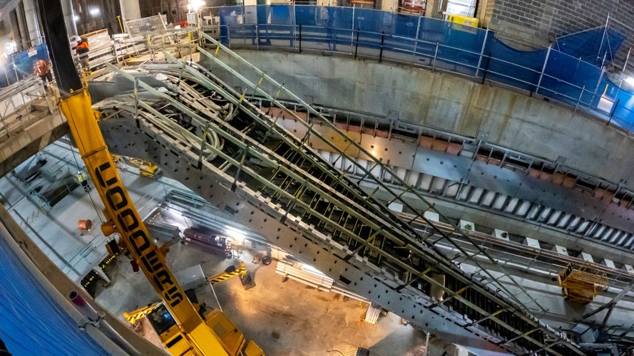 Heavy machinery lifting and installing escalators