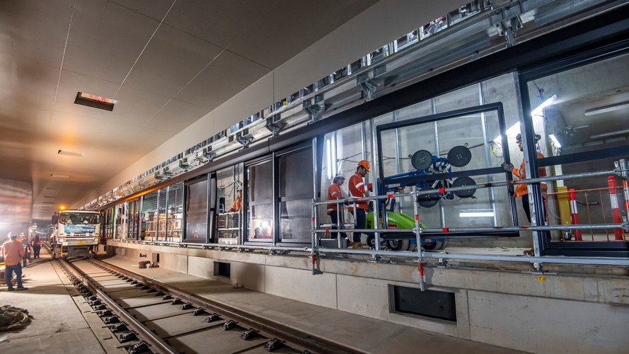 Construction workers installing platform screen doors in an underground platform