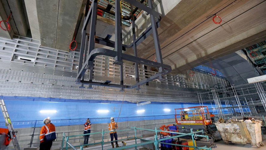 Construction workers supervising steel structure lift inside Barangaroo Station box