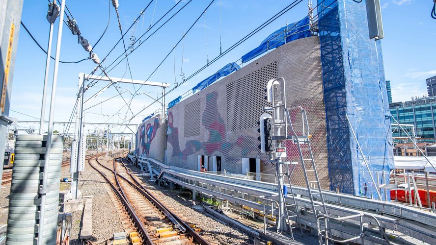 Colourful aboriginal artwork covers the brick ventilation buildings along the tracks at Central Station.