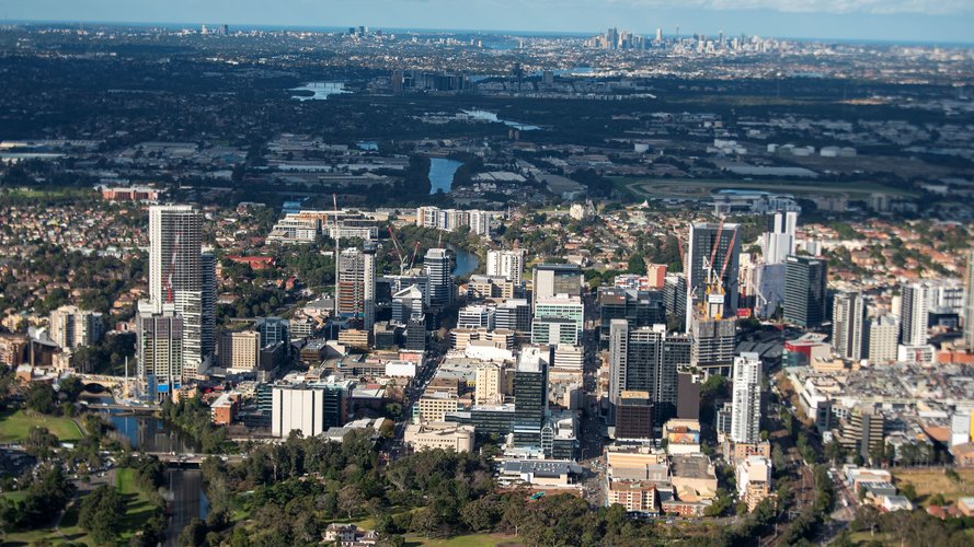 A bird's eye view of Parramatta showing the Sydney skyline and surrounding suburbs.