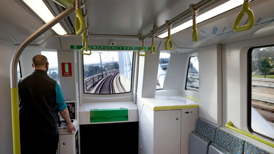 Worker standing at the front of a metro train testing train speed.