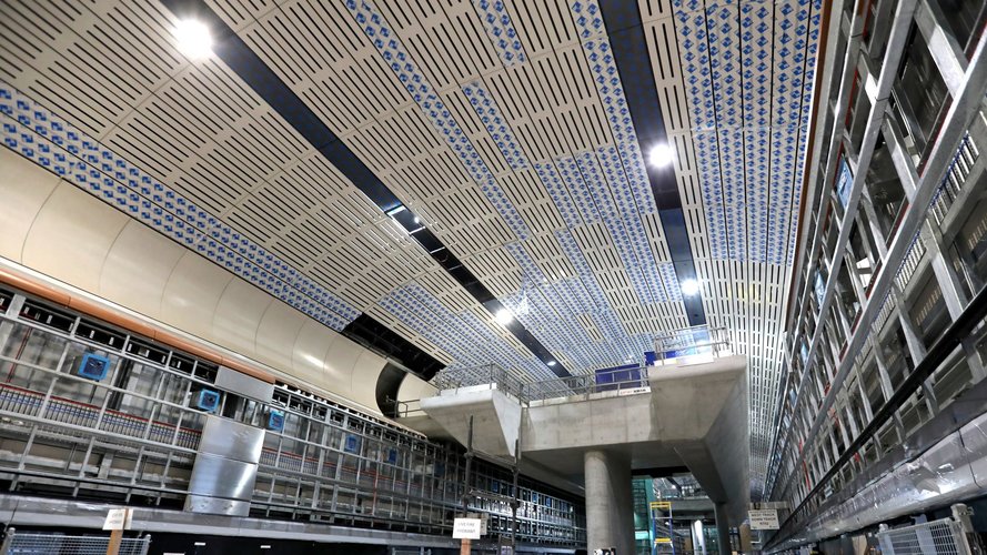 Low angle shot of mezzanine area and underground cavern ceiling at Sydney Metro's Victoria Cross Station.