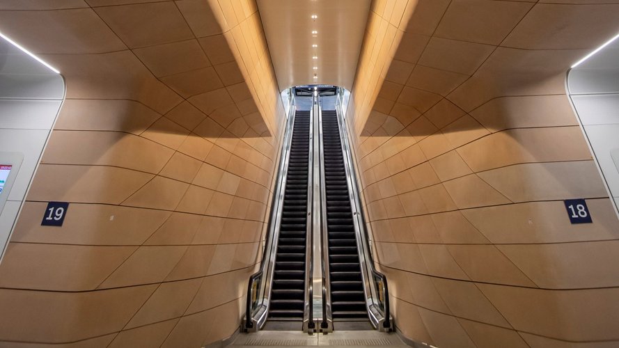 Long vertical shot of escalators and wall panelling in the underground pedestrian concourse at Central Station.