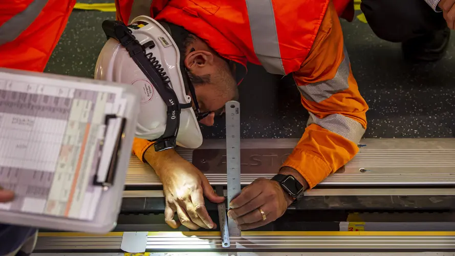 An engineer is testing the door of the train and platform screen door with a scale