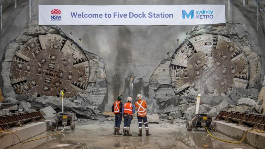 3 workers looking at the two TBMs at Five Dock Station