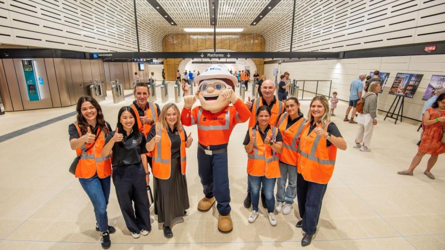 Mascot surrounded by people in high vis gear with their thumbs up