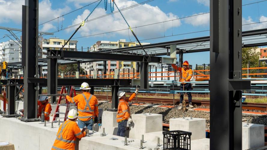 Workers in high visibility gear working on the installation of the Bankstown Metro platform