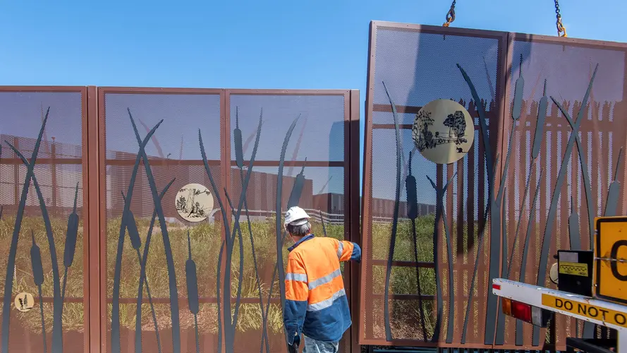 a worker at the Marrickville Station laying the fence